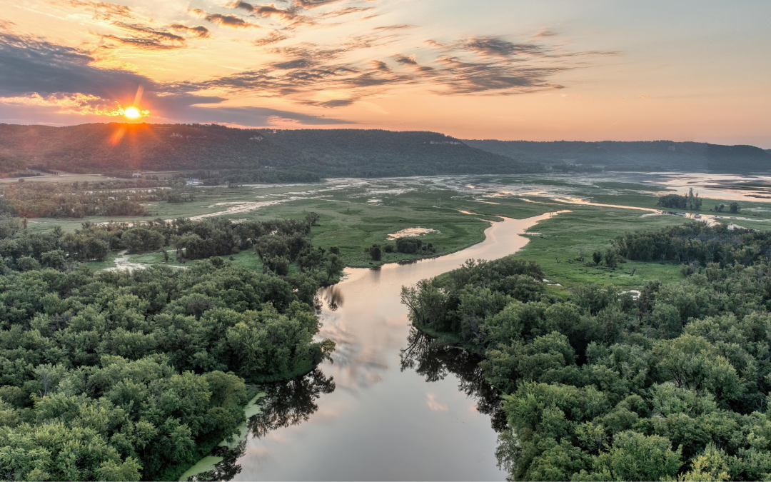 Aerial view of a river winding through South Mississippi wetlands at sunrise, highlighting flood-prone lowland areas.