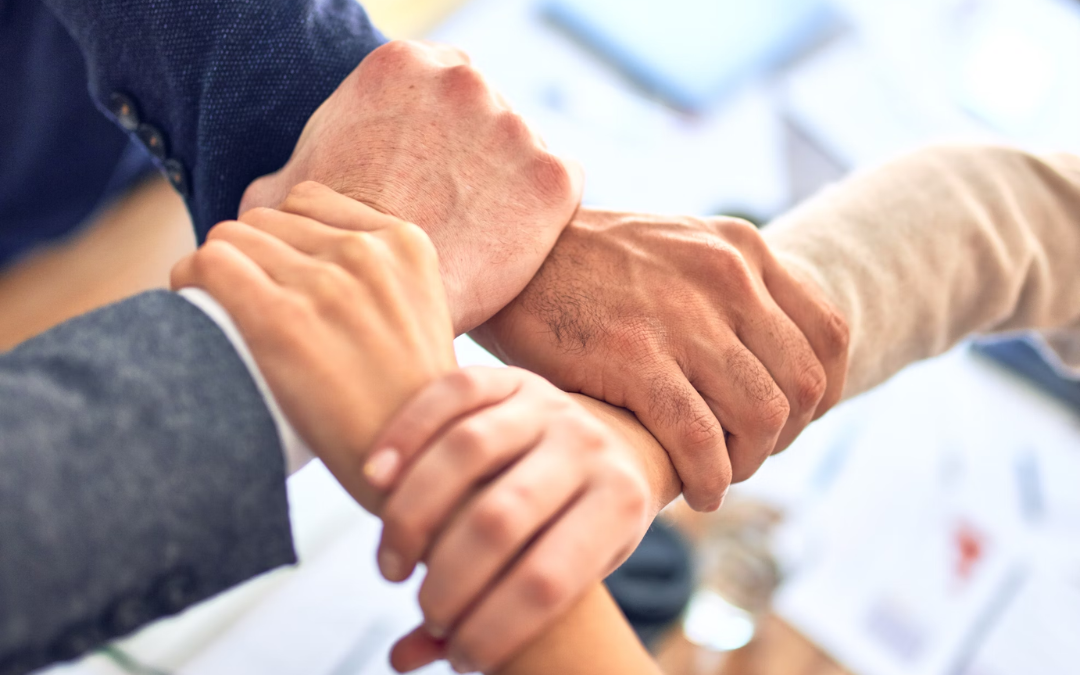 Hands of business colleagues stacked together in a gesture of teamwork and mutual support.